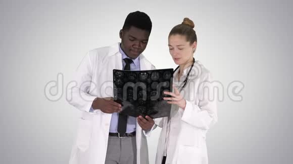 严肃善良的女医生和美国黑人医生在梯度背景下研究大脑x射线视频的预览图