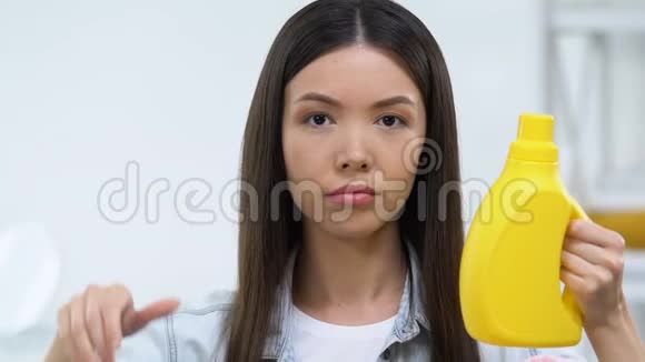 不满意的女人拿着洗洁精竖起大拇指不喜欢视频的预览图