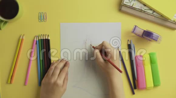 时装设计师用彩色铅笔绘制服装素描的俯视图视频的预览图