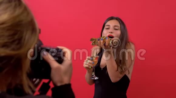 模特儿在镜头中向摄影师吹纸屑手里拿着一杯香槟摆姿势视频的预览图