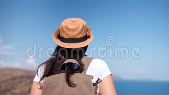 后景活动背包客女人欣赏美丽的海景接近山顶视频的预览图