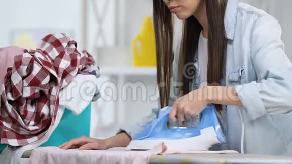 疲惫的家庭主妇熨衣服用手洗脸哭泣努力工作视频的预览图