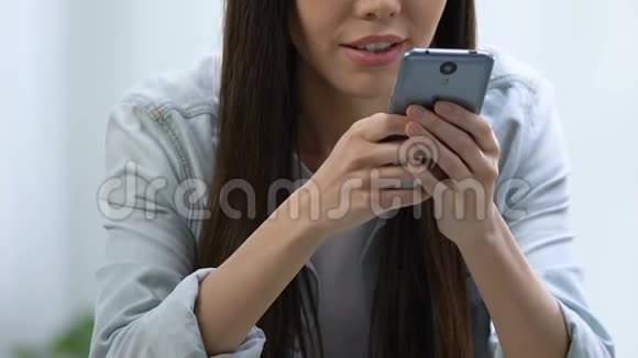 年轻的微笑的女人在智能手机上给心爱的新亲戚发短信视频的预览图