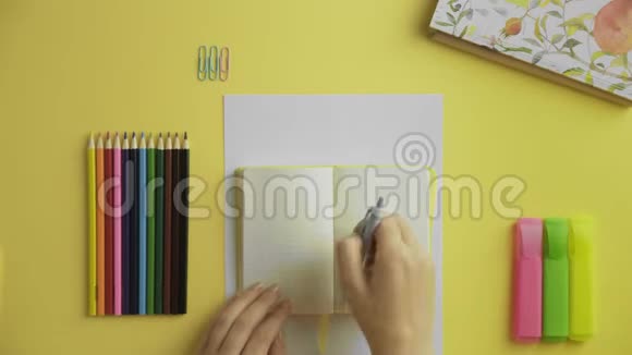 黄色日记中女性写作的俯视图视频的预览图