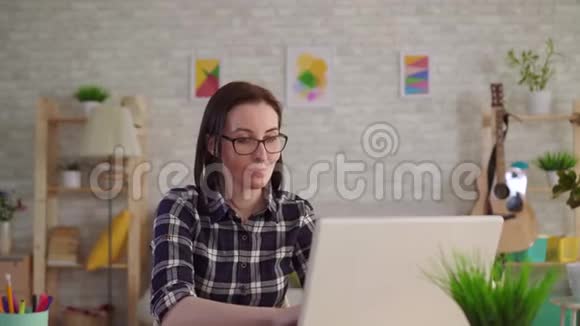 一个脸上有烧伤疤痕的年轻女人用笔记本电脑视频的预览图