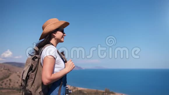 希普斯特轻松的背包女郎欣赏矗立在山峰上的迷人海景视频的预览图
