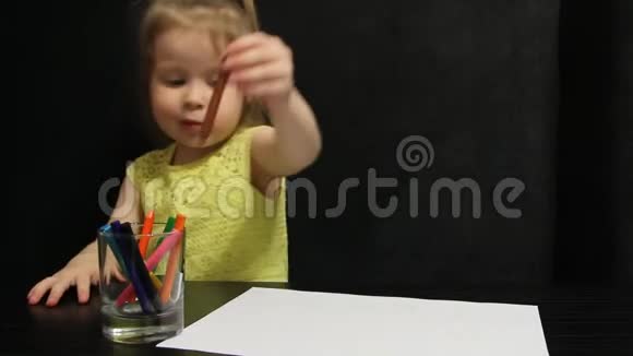 小女孩用棕色铅笔在纸上画画视频的预览图