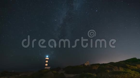 星空之夜银河在海岸景观和灯塔背景中的时间流逝视频的预览图