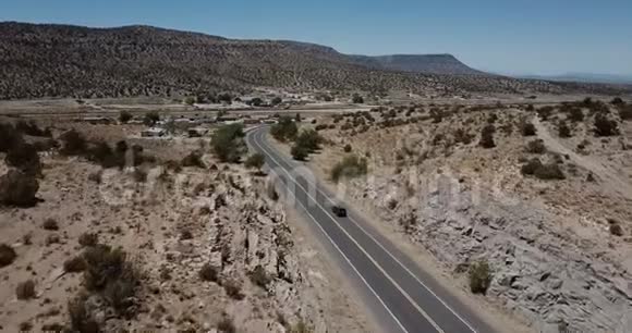 无人机跟随银色小型货车在美国亚利桑那州的夏季沿着美丽的沙漠山路行驶公路旅行概念视频的预览图