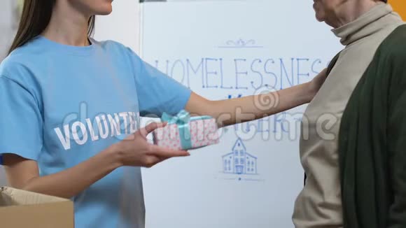 友善的女性志愿者为慈善中心的贫困妇女赠送礼品盒视频的预览图