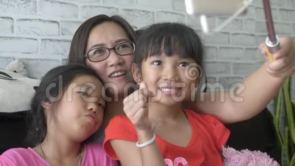 快乐亚洲家庭自拍与智能手机在客厅视频的预览图