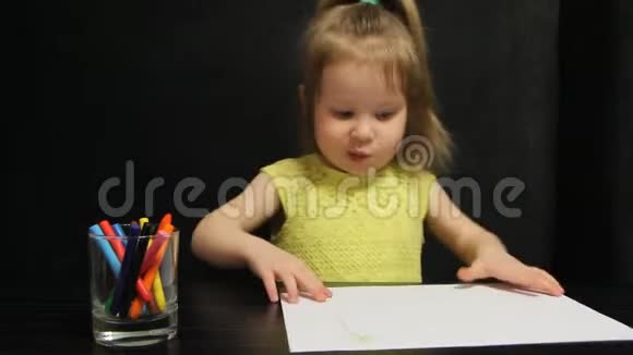 小女孩展示她的画纸和拇指向上视频的预览图