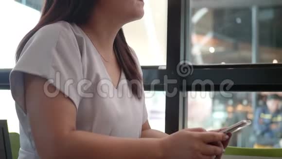 女人正在餐馆里等她的男朋友独自坐在桌子旁用智能手机检查时间视频的预览图