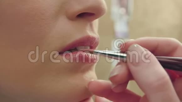 化妆师用画笔将唇彩涂成唇形视频的预览图