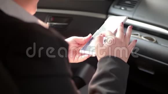 女人在车里的座位上使用智能手机视频的预览图