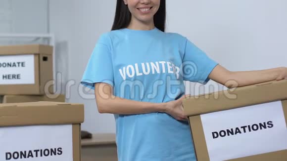 开放的女性志愿者手持捐款箱微笑着对着镜头关怀视频的预览图