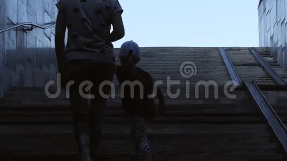 一个女人和一个小女孩牵着手上楼梯离开地下通道视频的预览图