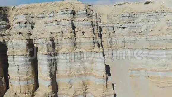 一个带着旅行背包的人在沙漠地区的一座粉笔山上行走视频的预览图