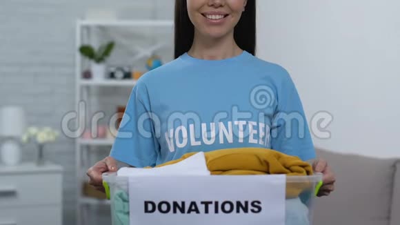 热心肠的年轻女子拿着装有捐赠衣物的盒子无家可归的照料中心视频的预览图
