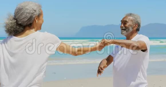 浪漫的活跃的非裔美国人夫妇在海滩上一起跳舞的正面景色视频的预览图
