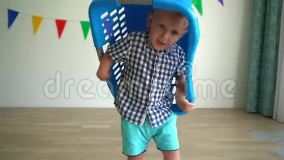 疯狂的蹒跚学步的男孩头上有塑料盒子积极转动万向节运动视频的预览图