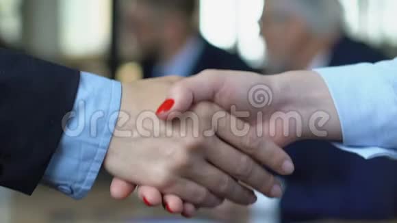 女商人与男伴握手雇用女雇员特写视频的预览图