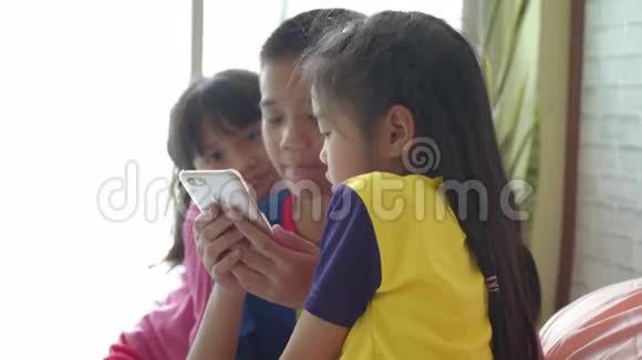 孩子们使用智能手机在家里放松视频的预览图