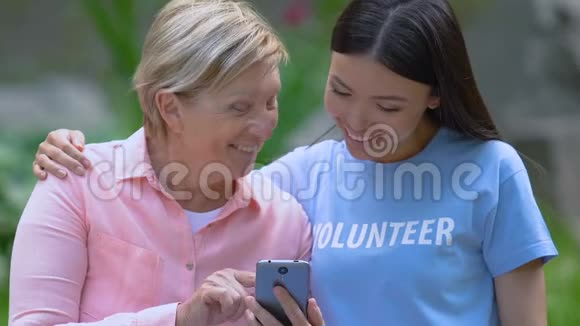 老年女性向青年志愿者展示家庭照片视频的预览图