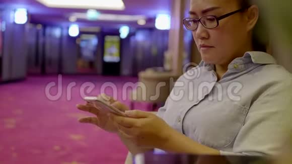 女人在电影院前面用手机视频的预览图