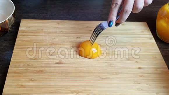 女孩用菜刀在木板上切一个保守的桃子视频的预览图
