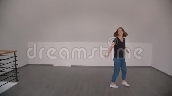 在舒适的公寓里年轻漂亮的白种人女性在室内愉快地跳舞和微笑视频的预览图