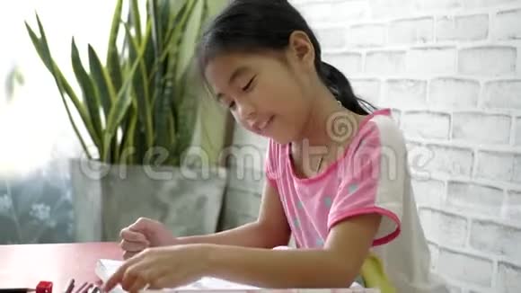 亚洲女孩在客厅做作业视频的预览图
