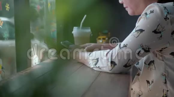 有智能手机的女人在咖啡馆喝咖啡视频的预览图