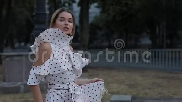 美丽的快乐女人穿着裙子在夏城小巷散步慢动作视频的预览图