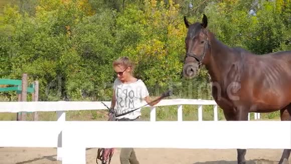 骑手牵着马的缰绳去骑手和马在训练后一起去动物护理概念视频的预览图