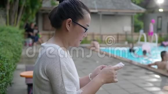 女子在游泳池使用手机短信视频的预览图
