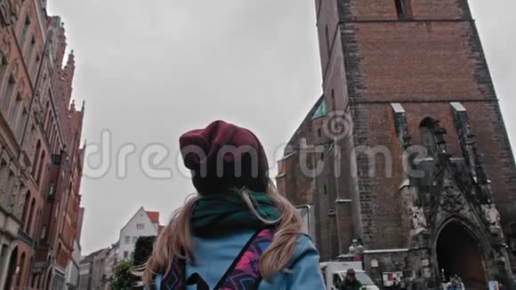 旅游女孩带着背包探索和考虑视线古老的天主教教堂红砖教堂德国视频的预览图