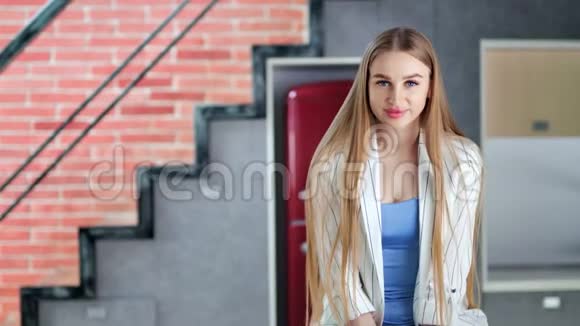 迷人的微笑年轻休闲女孩的肖像长着美丽的金发中镜头视频的预览图