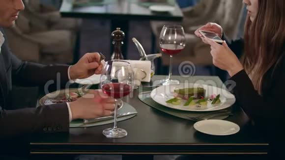 商务女性在餐厅用智能手机拍摄食物视频的预览图