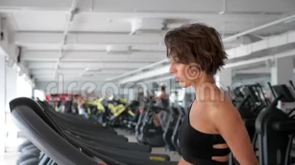 成熟的女人正在健身房的跑步机上训练健身运动理念视频的预览图