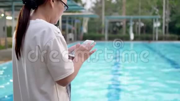 女子在游泳池使用手机短信视频的预览图