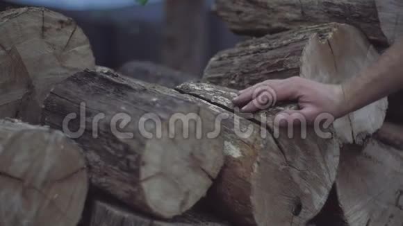 人的手感觉到橡木柴块的木质结构储存在一堆冬天视频的预览图