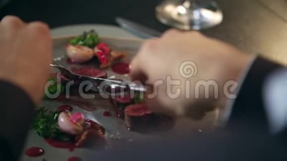 男性手在餐馆的盘子里切食物在餐馆吃肉的男人视频的预览图