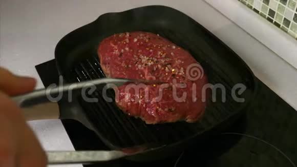 手拿金属铜把烤牛肉牛排烤盘视频的预览图