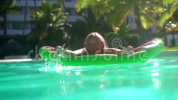 漂亮的女模特尺寸加上太阳镜在水上的床垫上放松概念度假旅游视频的预览图