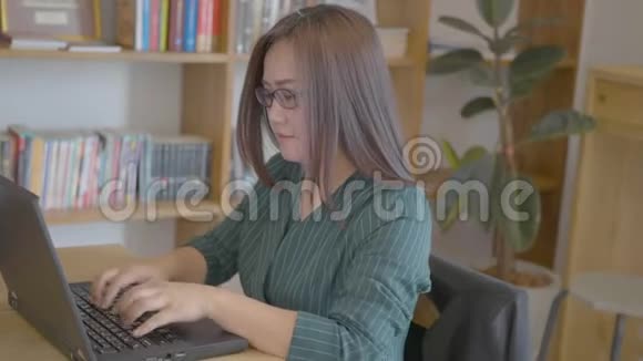 在家庭办公室里用笔记本电脑工作的女人视频的预览图