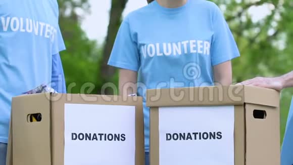 微笑志愿者在室外捐赠箱附近捐赠5个高5个视频的预览图