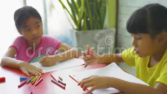 孩子们小女孩在家学习功课并在笔记本上写下视频的预览图