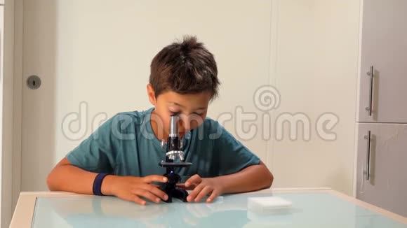 男孩正在研究显微镜幻灯片视频的预览图