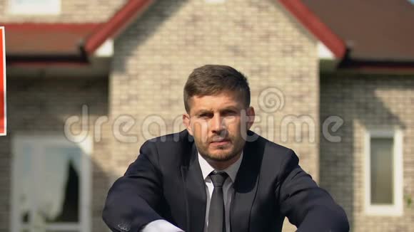 沮丧的男经理捂着脸双手坐在红色销售标志附近危机视频的预览图